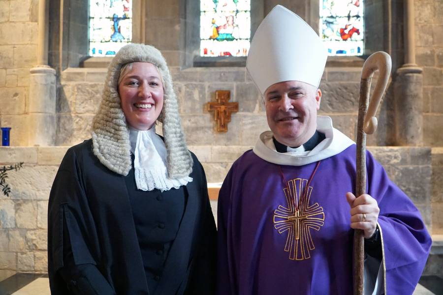 Woman dressed in lawyers wig and gown next to Bishop in purple robes and white mitre