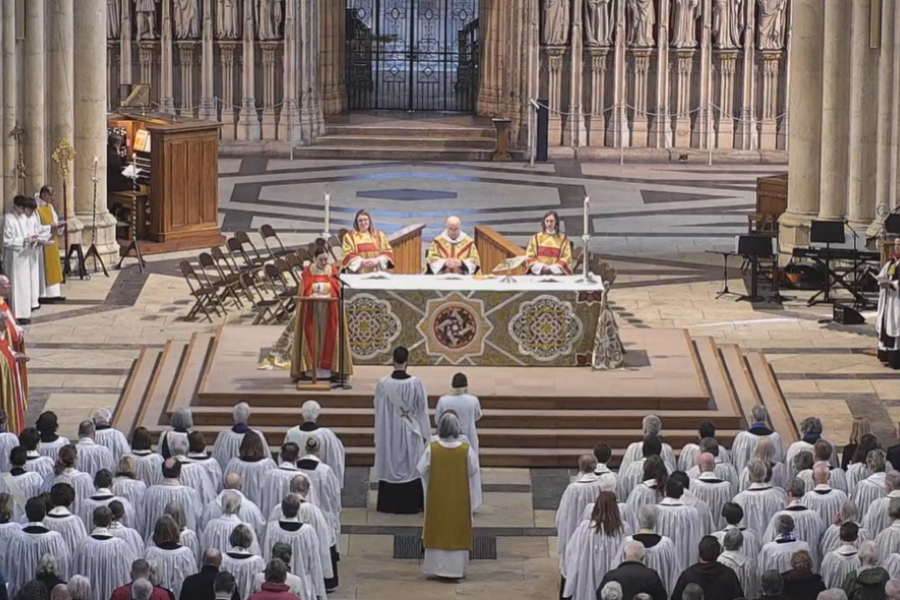 A service inside a large church - robed clergy in the congregation, facing the altar