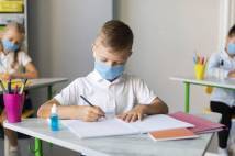 Child at school desk wearing a mask