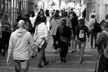 Greyscale photo of people walking in a town setting