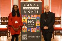A woman and a man standing next to a banner saying Equal Inclusive Rights