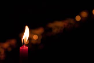 A red candle lit in the darkness