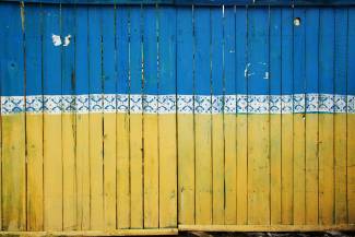 Fence boards painted in colours of Ukrainian flag, blue and yellow