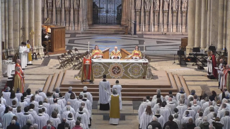 A service inside a large church - robed clergy in the congregation, facing the altar
