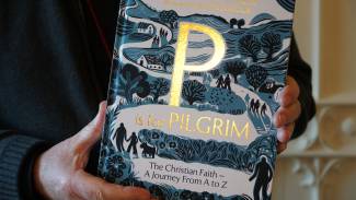Front cover of a book P is for Pilgrim  in gold lettering on a drawn picture of people following a winding path