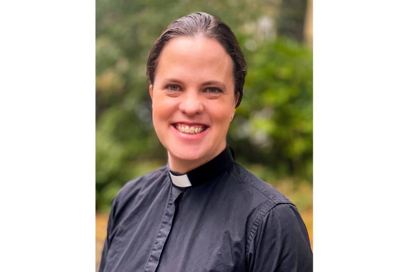 Head and shoulders of smiling female priest 
