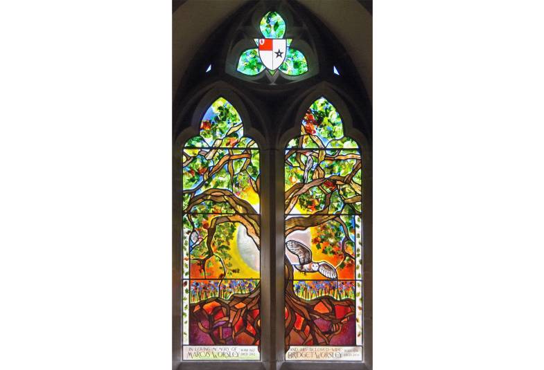 Stained glass window in situ depicting a tree and birds