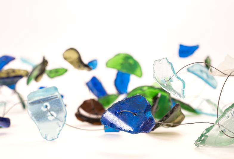 Pieces of coloured glass wired together in  string