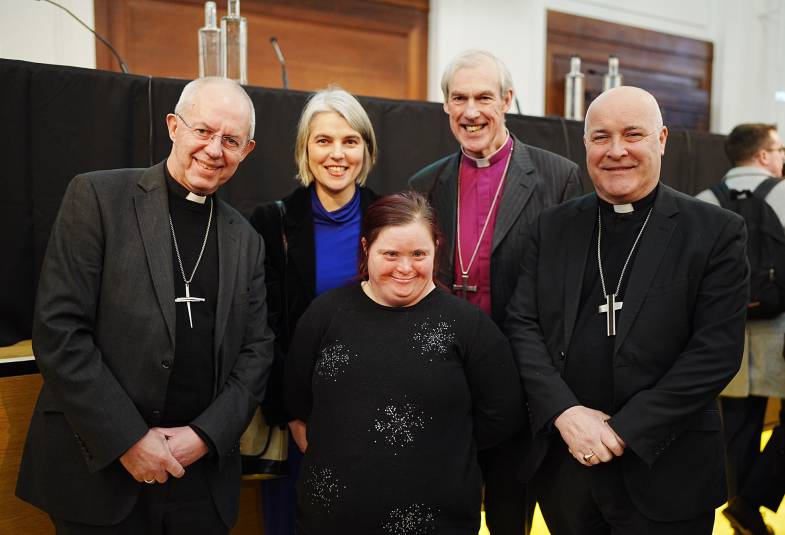 Group of smiling people including 3 dressed as bishops