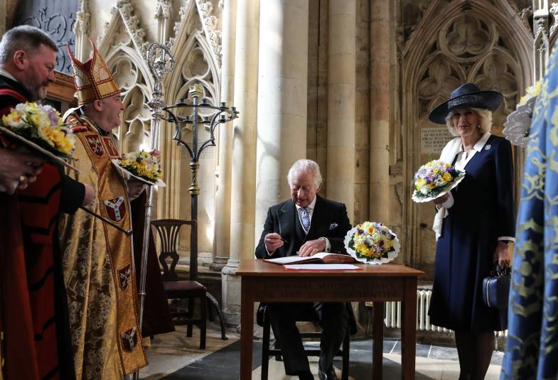 Man sat at desk inside a church signing a document