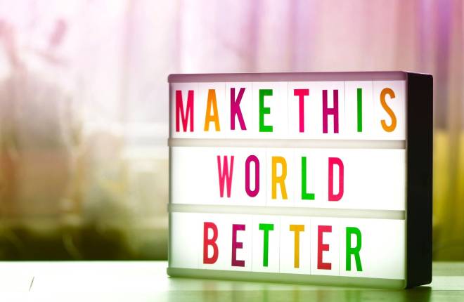 A light box with the words Make this world better in different coloured letters