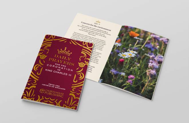 A burgundy coloured book with another opened book showing words on one page and flowers on the other