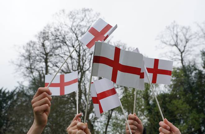 hands holding St George's flags in the air